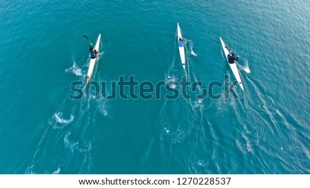 Aerial drone photo of young men competing with sport canoe in tropical port with calm sea