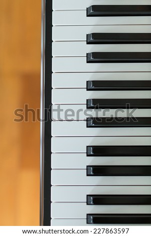 Top view of  a piano keyboard with wooden floor background