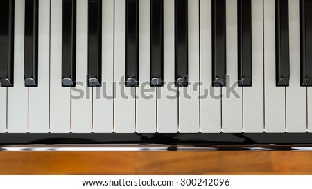 Close up of Piano keyboard with wooden floor background.