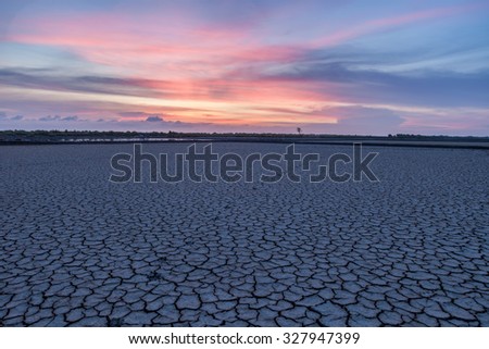 Drought land with earth crack pattern with colorful sky at dawn with cool tone.