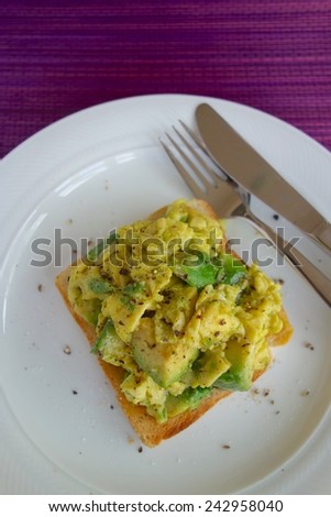 Scrambled eggs with avocado on toasted bread