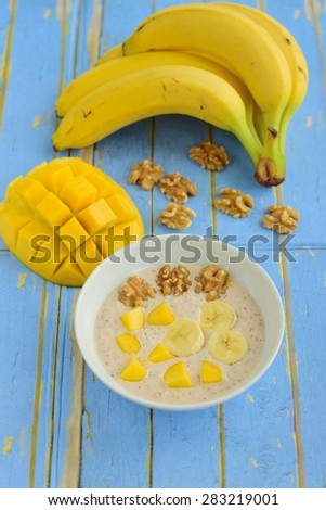 Banana Mango Walnut Overnight Oats in a Bowl on Blue Wooden Background