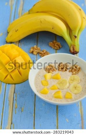 Banana Mango Walnut Overnight Oats in a Bowl on Blue Wooden Background