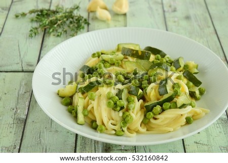 Pasta spaghetti with fresh peas, zucchini, thyme and parmesan cheese
