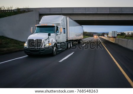 Semi-truck commercial vehicle 18 wheeler on highway with overpass