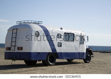 Old bus converted into a motor home parked in front of the sea, in Patagonia, Argentina.