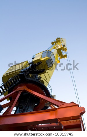 Heavy duty crane in yellow and orange. It has a copy space on top.