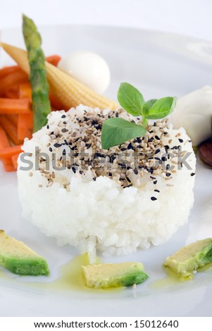 Rice and sesame seeds with carrots, baby corn, asparagus, quail eggs, avocado and olive oil. Focus on the rice.