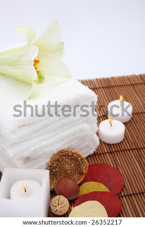 Towels, candles and flower on white background. Focus on towels.