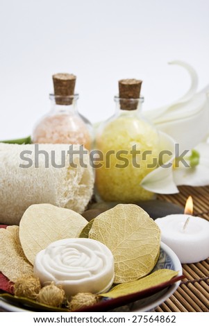 Bar of soap rose shaped, sponge, bath salts and candle. Focus on soap, decreasing to background.