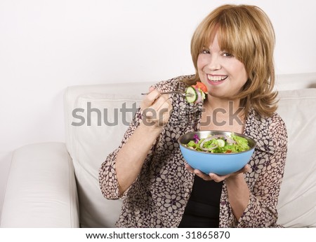 A 65 years old senior woman eating salad. No surgery, natural teeth: a good example of what good nutrition can do for you.