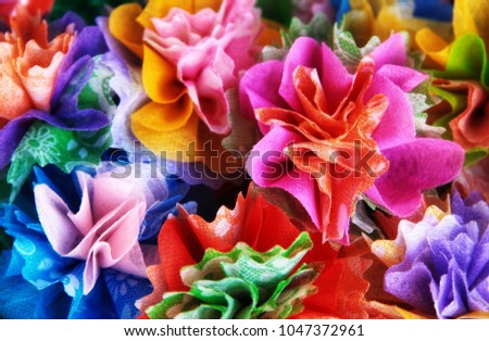 Colorful almsgiving ribbon-flowers. Close up colorful ribbon flowers and coins folding with mulberry paper for giving alms to make merit in Thai\'s religious traditional. It is a beautiful picture.
