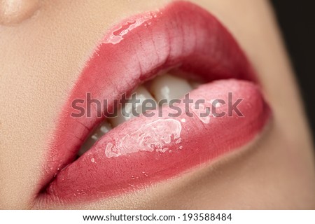Beautiful female with pink shiny lips close up.