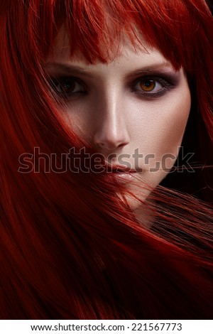 Beautiful portrait of woman with red hair on a black background hair