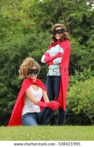 Super team of super heroes girl with red cape and red gloves outside in a forest
