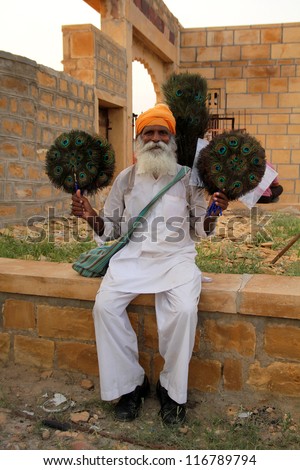 JAILSAMER - INDIA- SEPT 17: Old man sells handmade peacock fans.  World Bank stated, 32% of the total Indian people fall below international poverty line of US$ 1.25 per day on sept 17, 2012 in INDIA