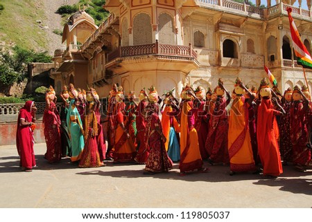 DEHLI, INDIA - SEPT 24 2012:  Colorful indian women wearing saris and carrying jars on their head to celebrate the return of the pilgrims on sept 24, 2012 in Delhi, India