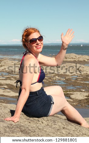 Back of a red hair woman shaking hands at the beach