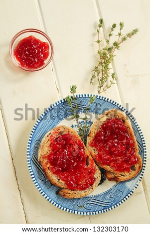 Nuts bread toast with strawberry jam and a little container with extra jam