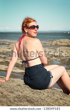Back of a red hair woman in bikini at the beach