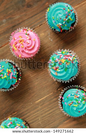 Top view of blue and pink icing cupcakes