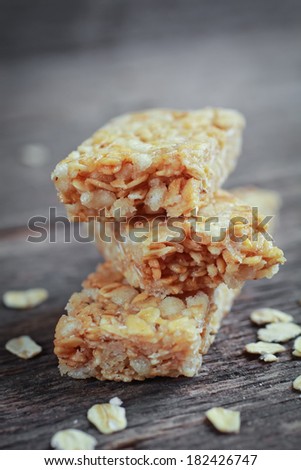 Three pieces of granola barre with fresh oat on a wooden table