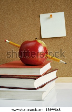 apple on book and blank note on wall