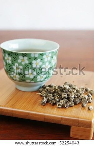 dragon pearl tea on wooden board with chinese cup