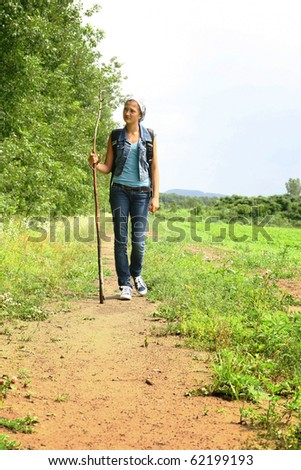 Lonely teenager girl walking into a path in a mountain