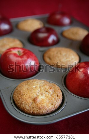 Apple muffins in a pan with red apples