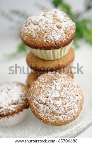 Fresh muffins with sugar powder on top in a white plate