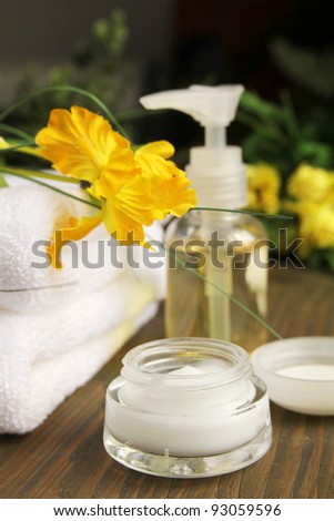 Cream, beauty items and towels on a wooden table