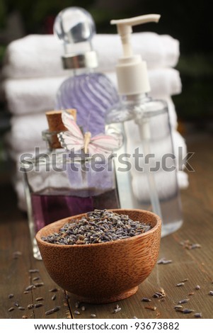 Lavender items, oil, cream, dried lavender and towels in background
