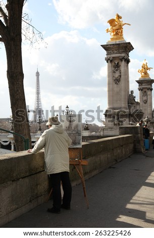 PARIS, FRANCE - MARCH 04, 2014:  Old man artist drawing the eiffel tower along the la seine river in Paris, France.