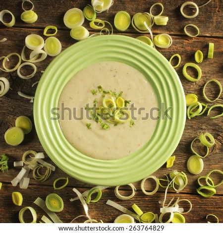 Top view of a bowl of leek soup surrounded by leek rings