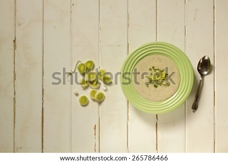 Top view of a bowl of leek soup with fresh leek rings