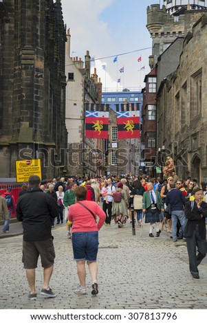 EDINBURGH, SCOTLAND - AUGUST 17, 2015:   Tourists walking in Edinburgh during the fringe festival the largest festival in the world.  Only the crowd and building in focus.