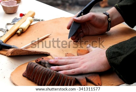A professional re-enactment craftsman making leather shoes like how it was done in the past