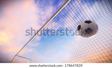 Soccer ball was floated into the goal on the football field at sunset.