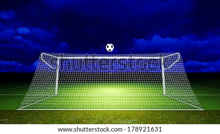 Soccer ball was floated into the goal on the football field at night.