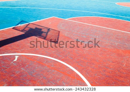 Concrete basketball court is empty in outdoor basketball field with shadow hoop