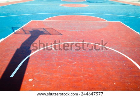 Concrete basketball court is empty in outdoor basketball field with shadow hoop