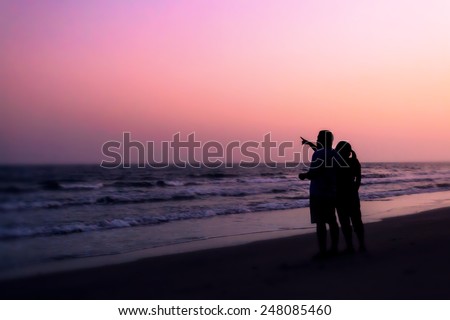 silhouette of couples hugging on the beach on the beach with sunrise in the sea for valentine\'s day