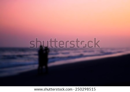 blurred and soft focus, silhouette of couples hugging on the beach on the beach with sunrise in the sea for valentine\'s day