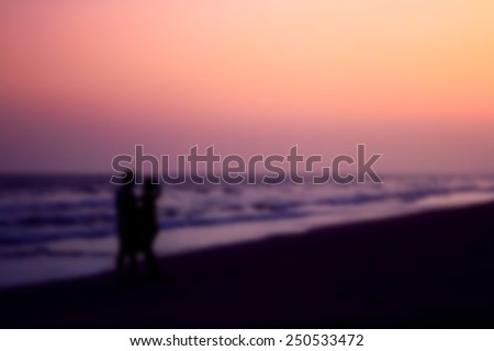blurred and soft focus, silhouette of couples hugging on the beach on the beach with sunrise in the sea for valentine\'s day