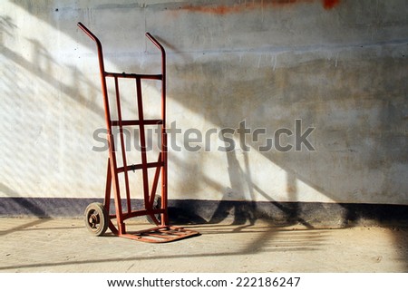 Red empty sack barrow or hand truck dolly  Beside old walls background
