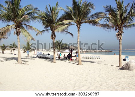 Recreation Park on the shores of the Persian Gulf in Dubai. Lawns, paths, trees and shrubs - all created by man on the bare sand. The beach is almost white.
