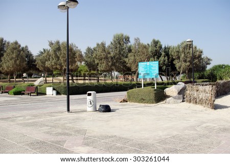 Recreation Park on the shores of the Persian Gulf in Dubai. Lawns, paths, trees and shrubs - all created by man on the bare sand. The beach is almost white.