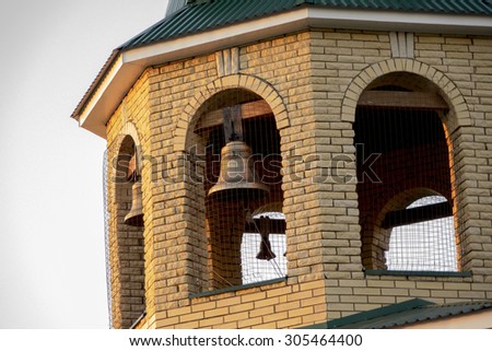 The village bell tower made of brick. The bells melted bronze. Shooting made at sunset.