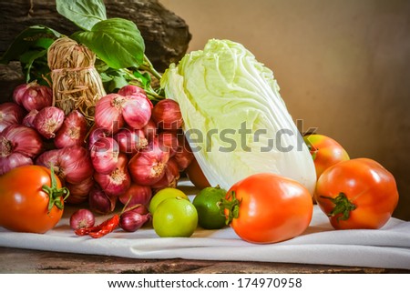 Still life of mix vegetable arranged with white fabrics and logs place on old wooden